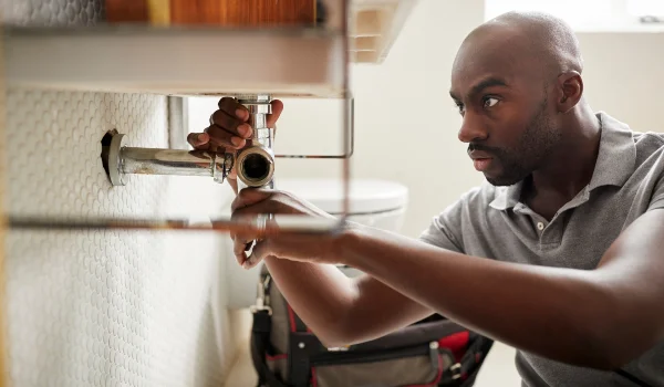 a male plumber fixing a pipe connection from Emergency Plumber Cedar Park in Cedar Park, TX 